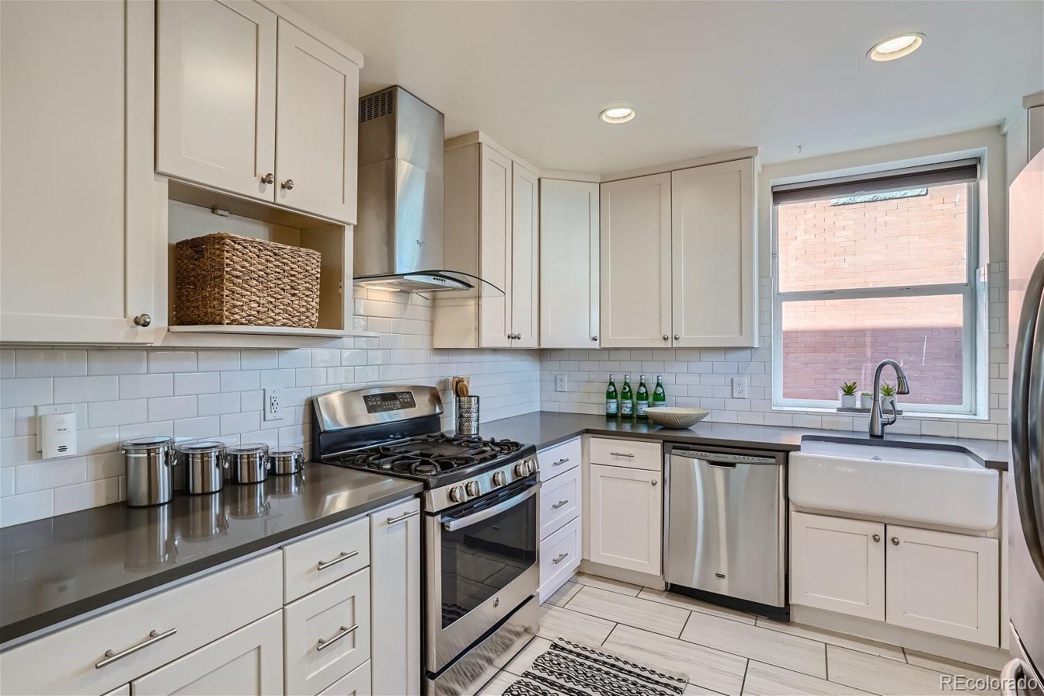 1516 Cook Street Denver, CO 80206 - Photo 9 of 35 a kitchen with white cabinets sink and stainless steel appliances