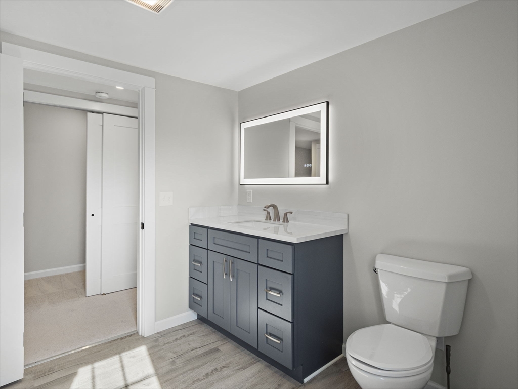 210 John Dyer Road Little Compton, RI 02837 - Photo 26 of 42 a bathroom with a toilet a sink a vanity and mirror