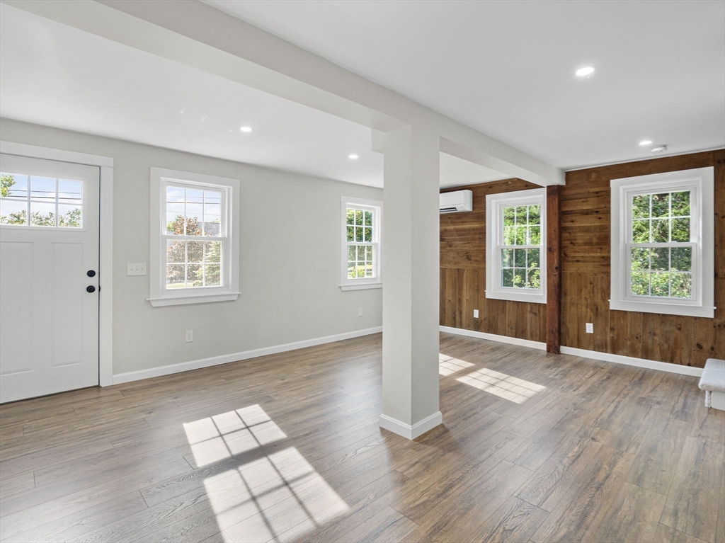 210 John Dyer Road Little Compton, RI 02837 - Photo 10 of 42 an empty room with wooden floor and windows