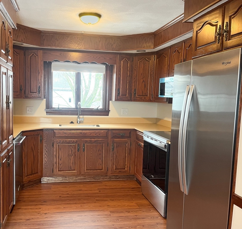 4 Gardner Street, Unit 2 Peabody, MA 01960 - Photo 2 of 13 a kitchen with stainless steel appliances granite countertop a refrigerator and a sink