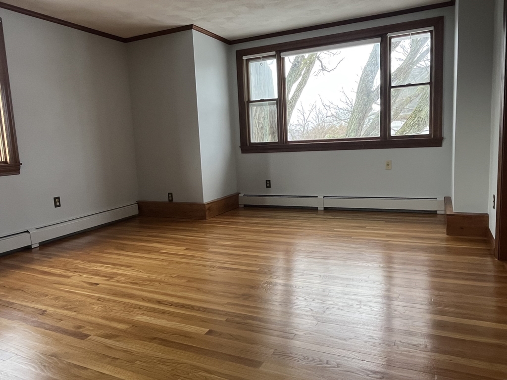 4 Gardner Street, Unit 2 Peabody, MA 01960 - Photo 9 of 13 an empty room with wooden floor and windows