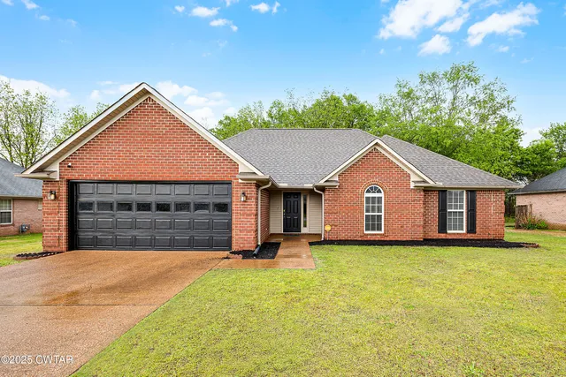 a front view of house with yard and garage