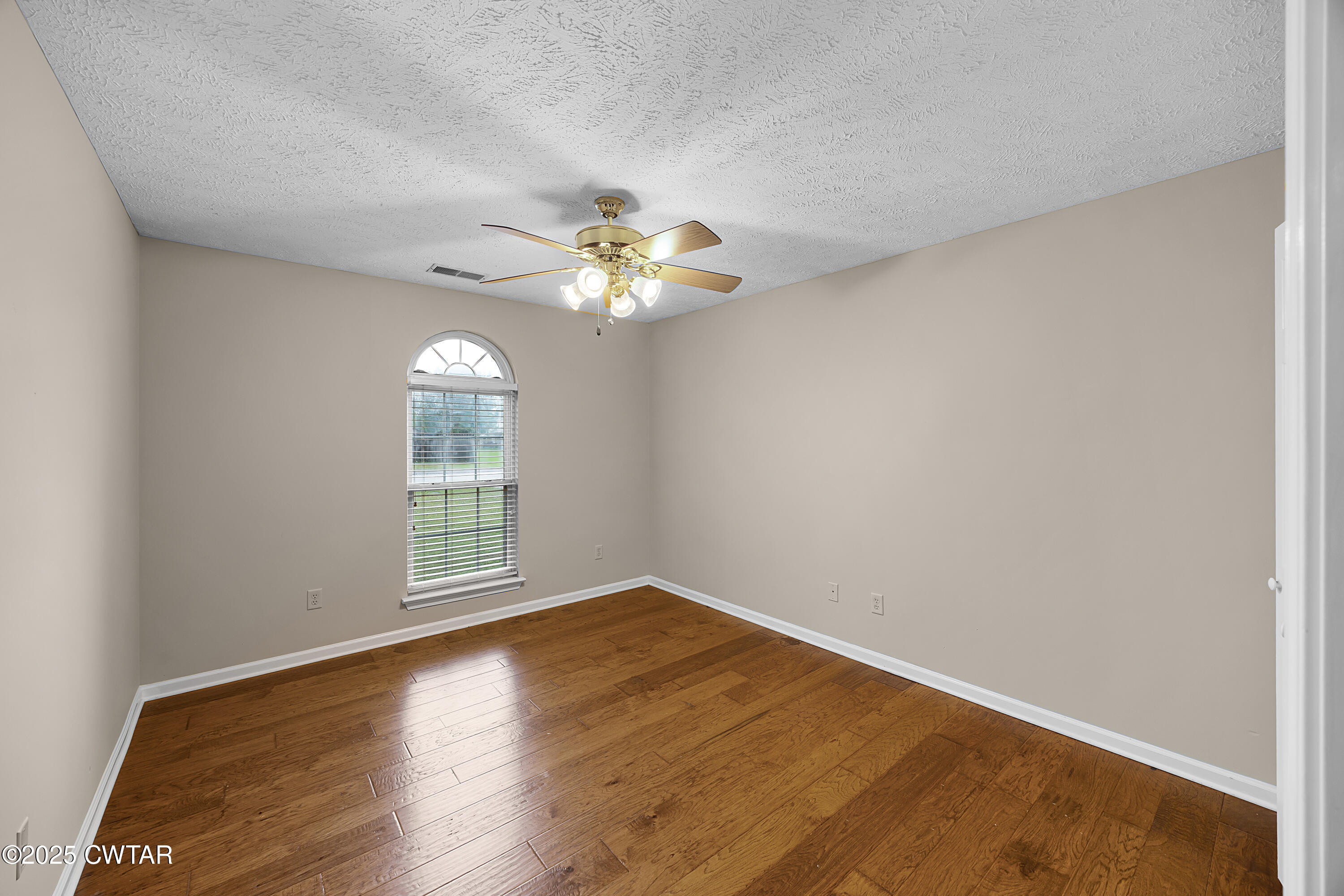 98 Cotton Ridge Drive Jackson, TN 38305 - Photo 12 of 20 an empty room with wooden floor and windows