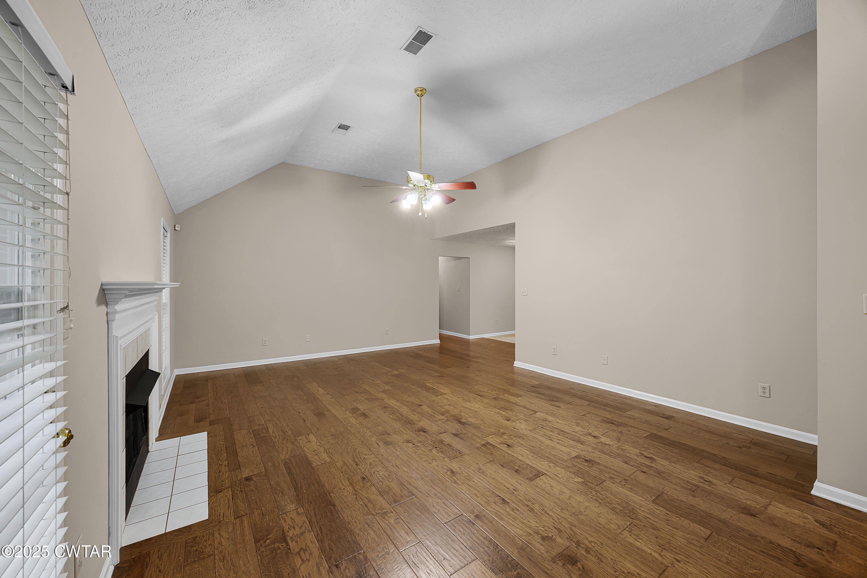98 Cotton Ridge Drive Jackson, TN 38305 - Photo 7 of 20 a view of an empty room with wooden floor and a ceiling fan