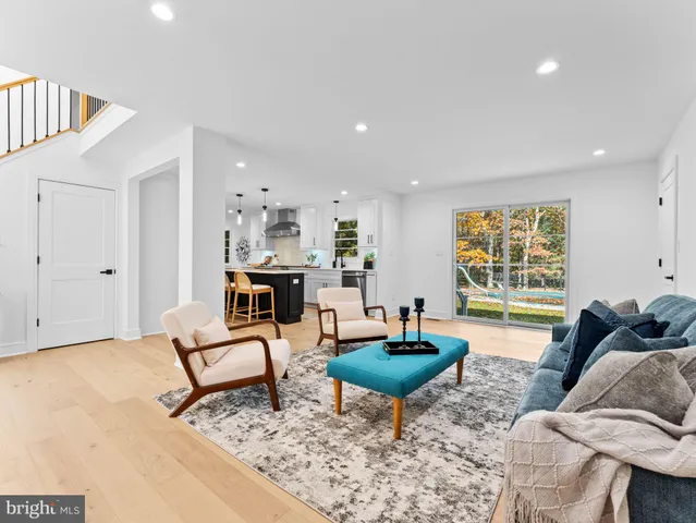 a kitchen with stainless steel appliances granite countertop a stove a sink a oven a dining table and chairs with wooden floor