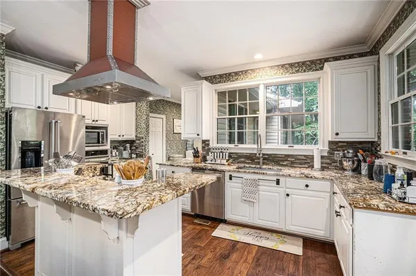 a kitchen with granite countertop a sink stove and cabinets