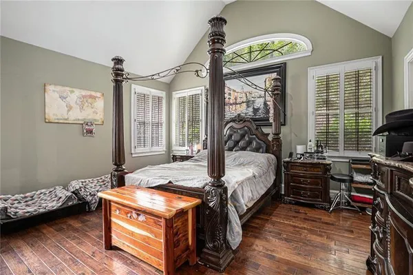 a bedroom with bed and wooden floor