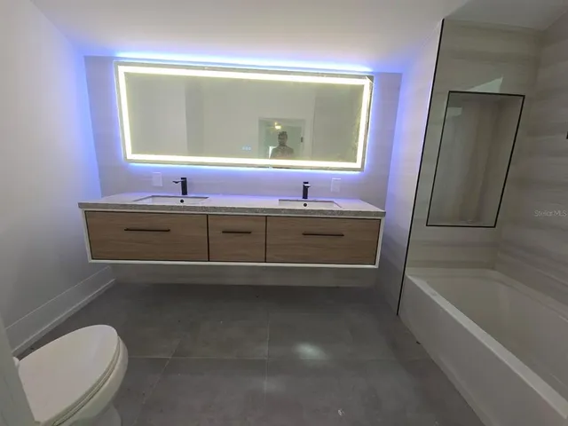 a bathroom with a toilet a sink and mirror