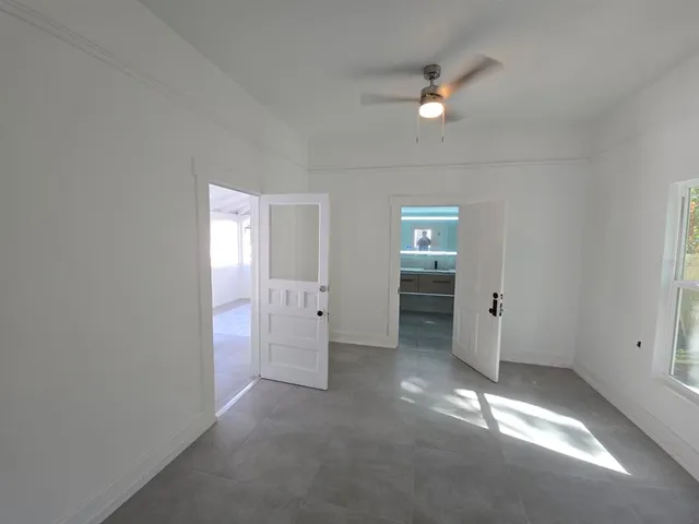 an empty room with closet and windows