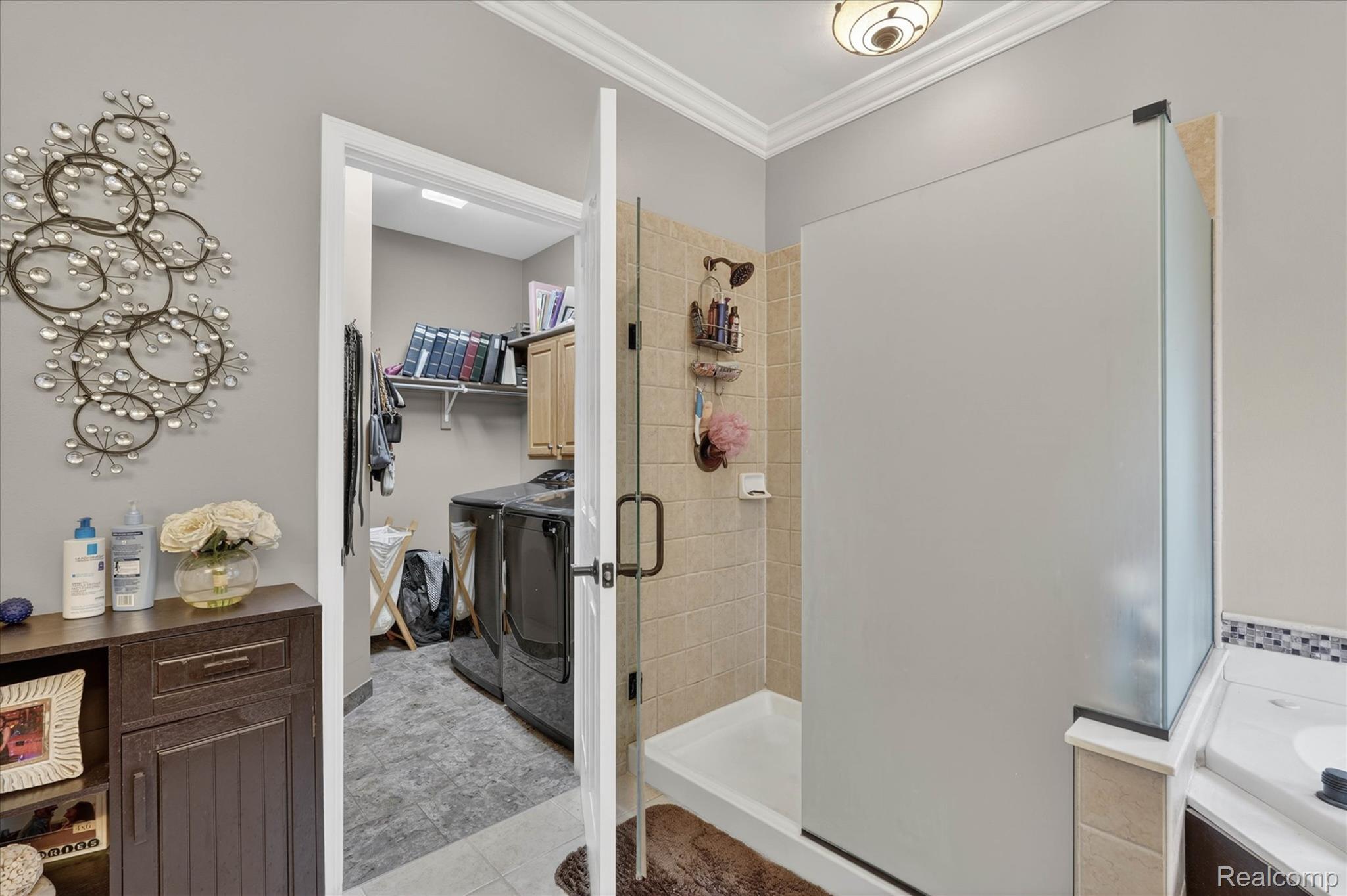 9074 Ridgefield Drive Brighton, MI 48114 - Photo 51 of 75 Bathroom featuring a spacious closet, washing machine and dryer, a stall shower, ornamental molding, and vanity