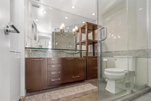 a bathroom with a granite countertop sink a toilet and a mirror