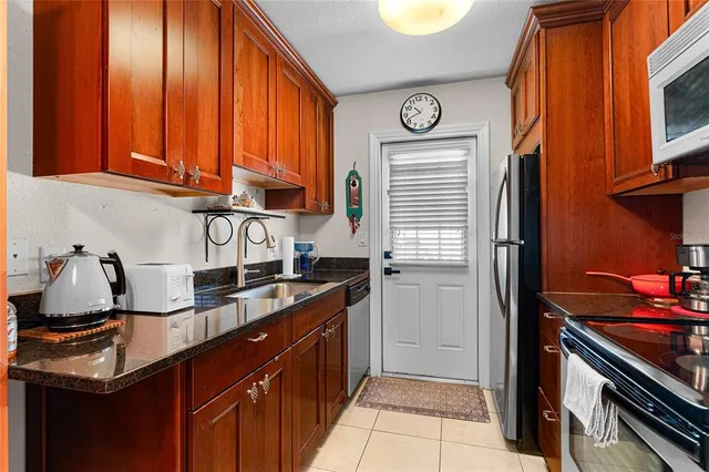 a kitchen with stainless steel appliances granite countertop a stove a refrigerator and a microwave