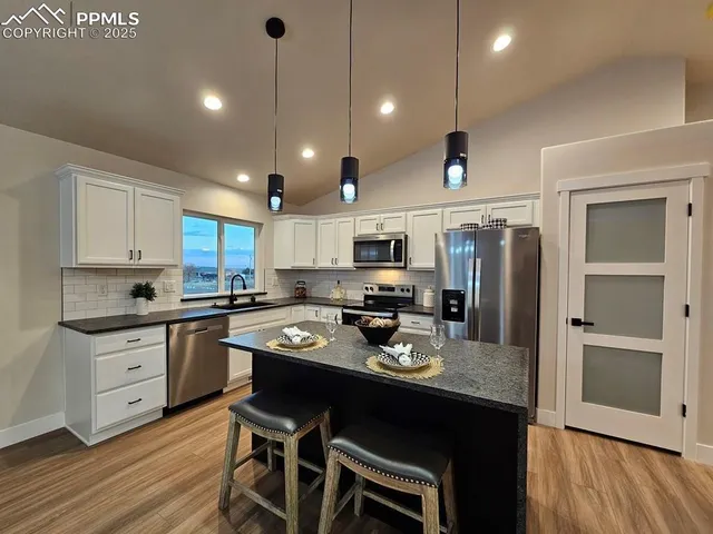 a kitchen with refrigerator cabinets and dining table
