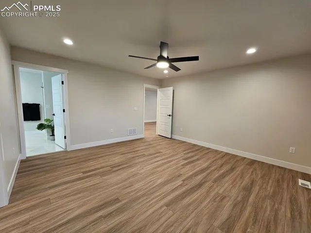 a view of empty room with wooden floor