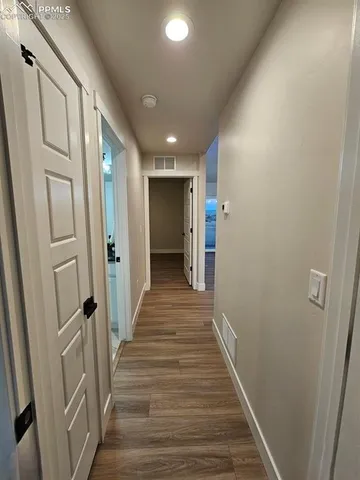 a view of an empty room with wooden floor