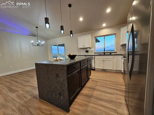 a large kitchen with stainless steel appliances granite countertop a stove a sink dishwasher and a refrigerator