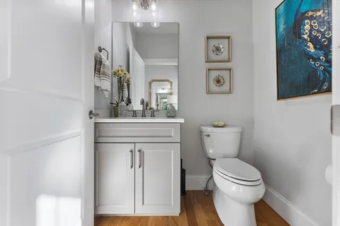 a bathroom with a sink vanity mirror and toilet