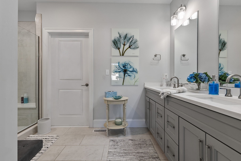 15 Rowell Lane, Unit 15 Middleton, MA 01949 - Photo 18 of 39 a spacious bathroom with a granite countertop sink a toilet and a mirror