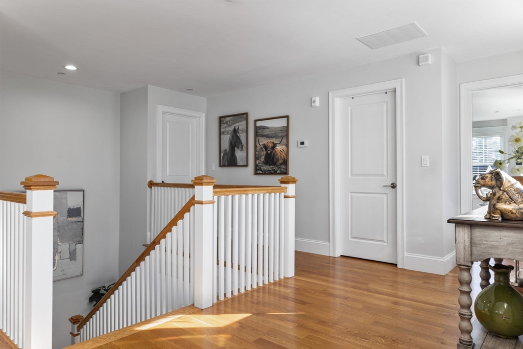 15 Rowell Lane, Unit 15 Middleton, MA 01949 - Photo 26 of 39 a view of a hallway to a livingroom with wooden floor and stairs