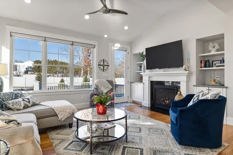 a living room with furniture a fireplace and a flat screen tv