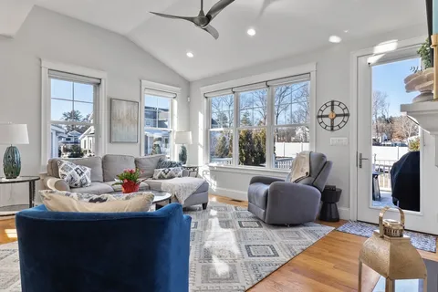 a living room with furniture flat screen tv and a large window