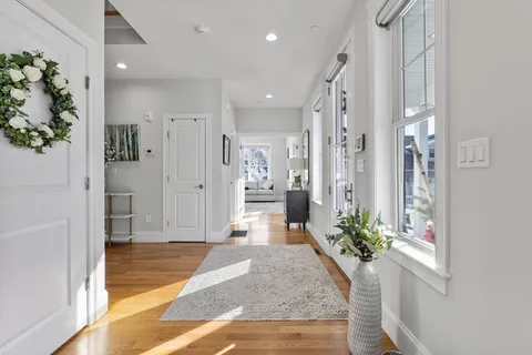 a view of an entryway of house and hallway with wooden floor