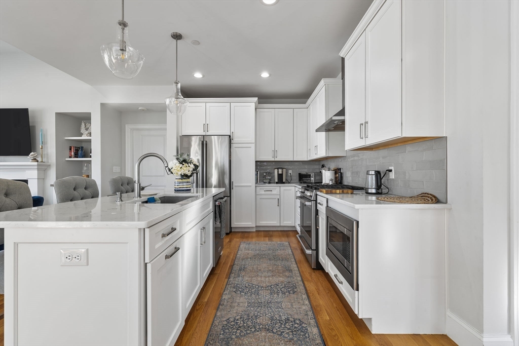 15 Rowell Lane, Unit 15 Middleton, MA 01949 - Photo 10 of 39 a kitchen with stainless steel appliances granite countertop a stove a sink a refrigerator and white cabinets