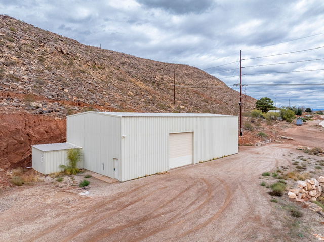 View of outbuilding with dirt driveway