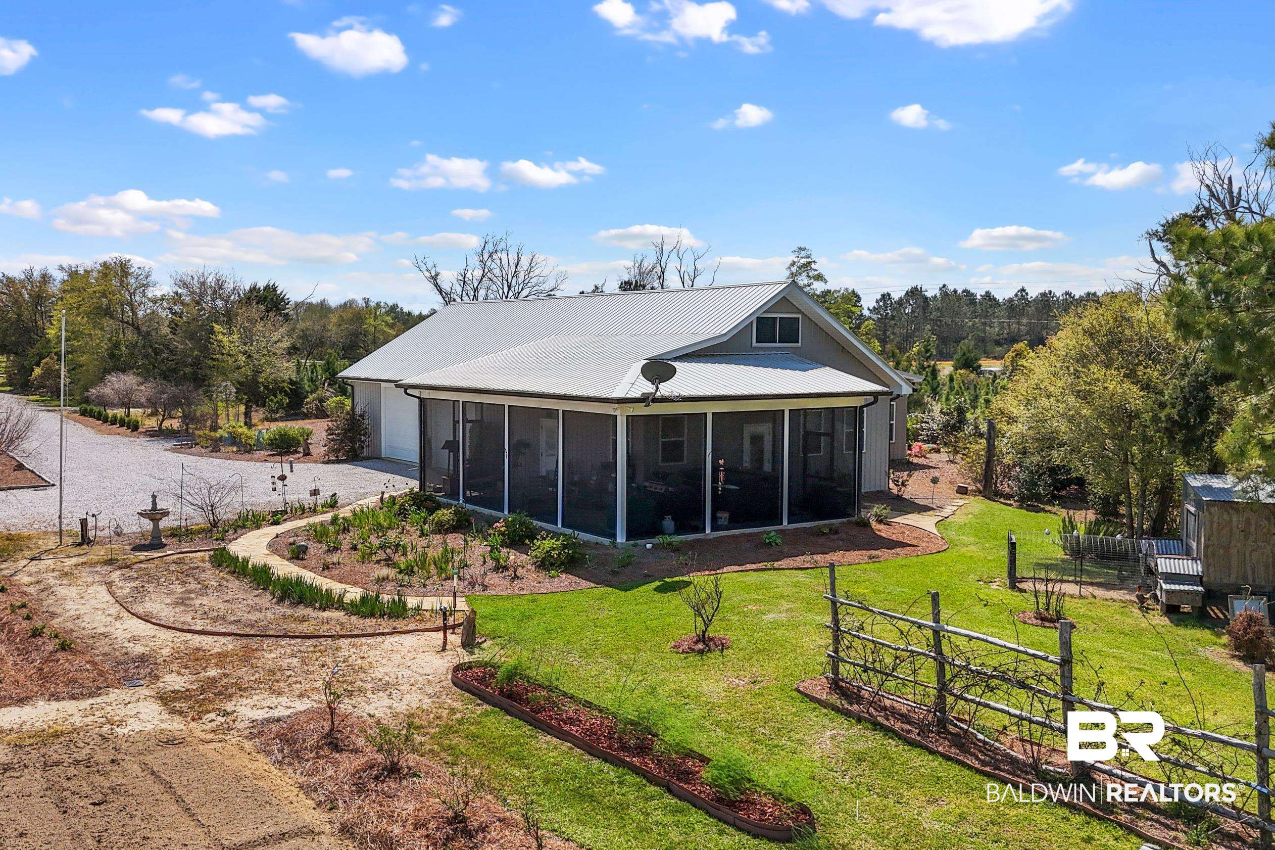 26071 Woerner Road Elberta, AL 36530 - Photo 6 of 86 Rear view of property featuring fence, a sunroom, a garage, and a yard