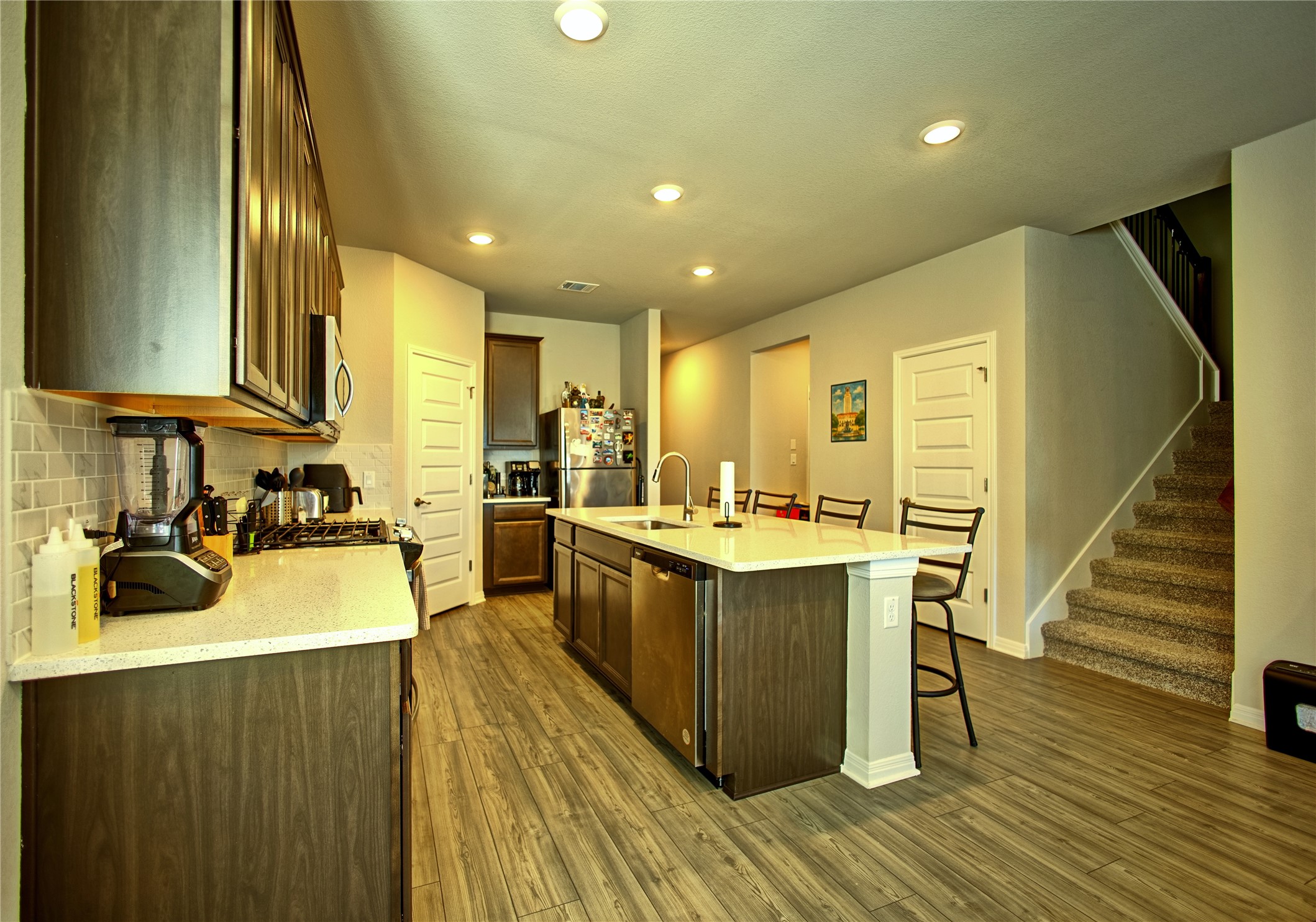 2809 Moyer Lane Round Rock, TX 78665 - Photo 3 of 22 Kitchen with a kitchen breakfast bar, stainless steel appliances, a center island with sink, light stone counters, and recessed lighting