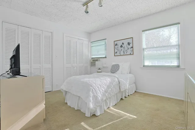 a bedroom with a bed dresser and a window