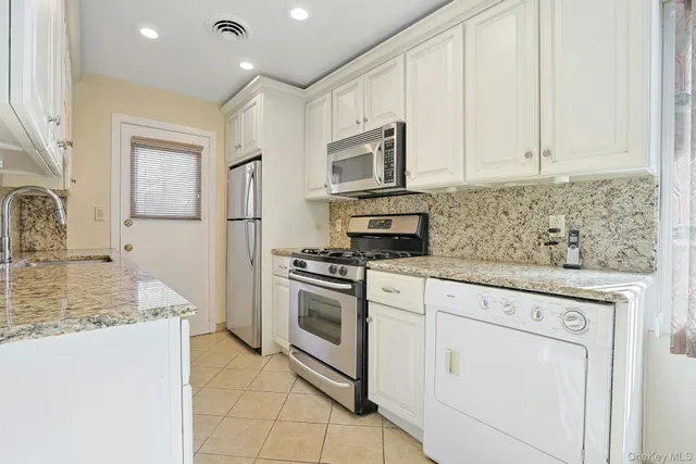 a kitchen with granite countertop a sink stove and cabinets