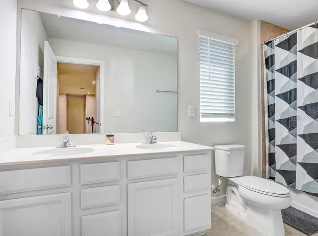 a spacious bedroom with a bed and a flat screen tv