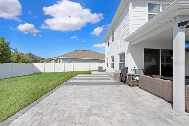 a view of an house with backyard and porch