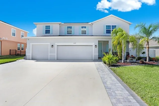 a front view of a house with a yard and garage