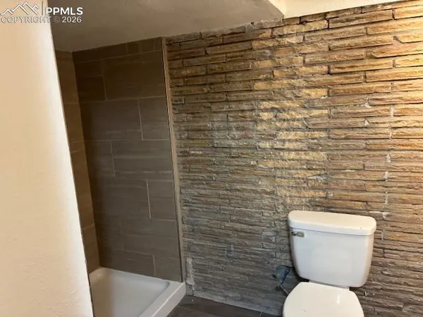 a bathroom with a toilet and a shower