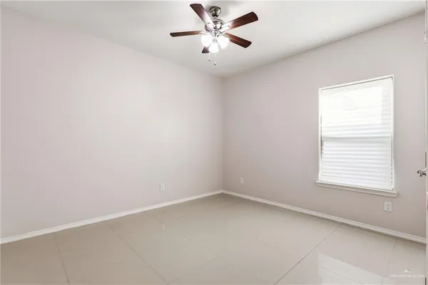 an empty room with a window and a fan