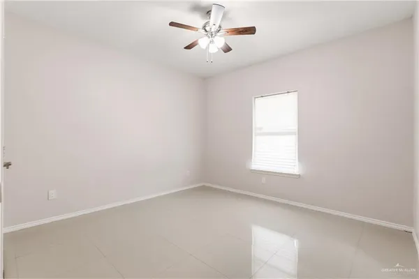an empty room with a window and a fan