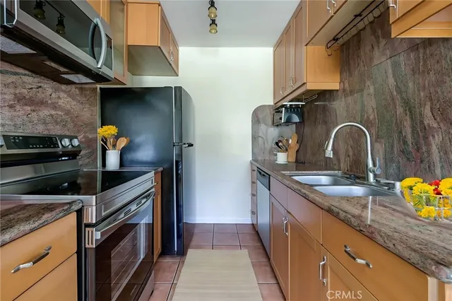 a kitchen with stainless steel appliances granite countertop a sink a stove and cabinets