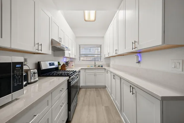 a kitchen with granite countertop a sink stainless steel appliances and cabinets