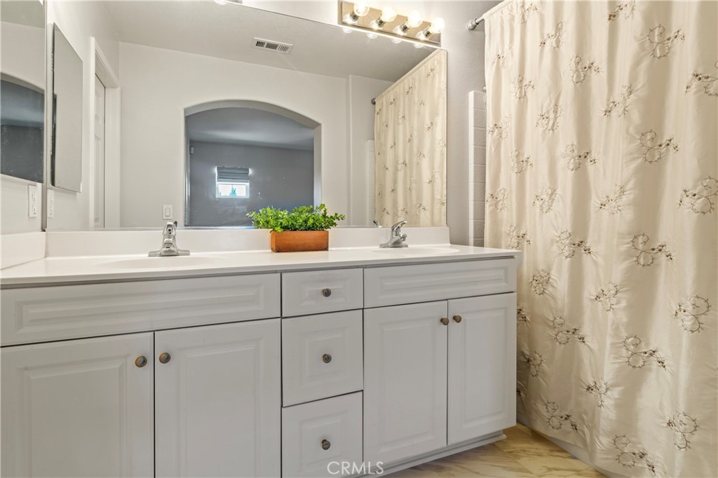 1339 Castledale Street Riverside, CA 92501 - Photo 19 of 27 a bathroom with a double vanity sink and a mirror