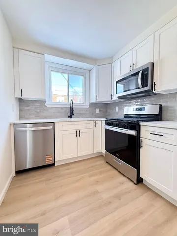 a view of a big room with a ceiling fan and a window