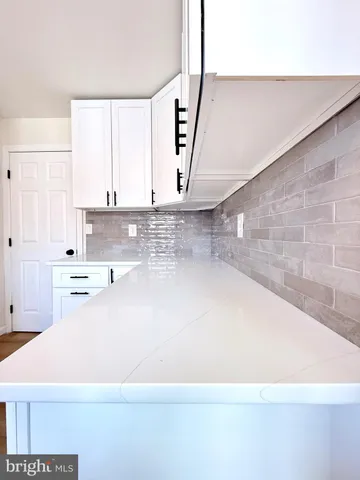 an empty room with windows and ceiling fan