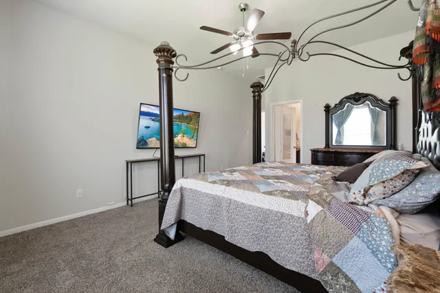 a bedroom with a bed a chandelier and dresser