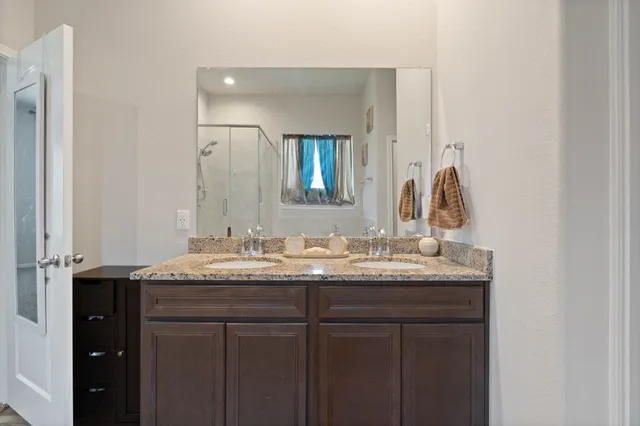 a bathroom with a granite countertop sink and a mirror