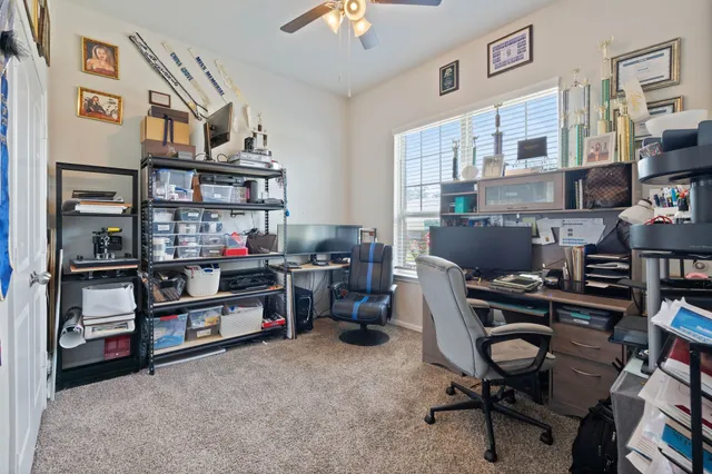 a view of a workspace with furniture and a window