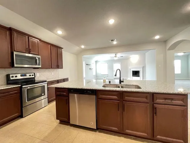 a kitchen with sink a microwave and cabinets