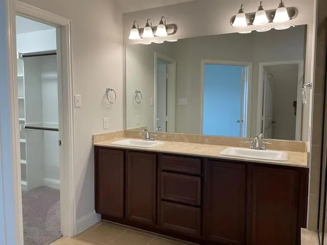 a bathroom with a double vanity sink and a mirror