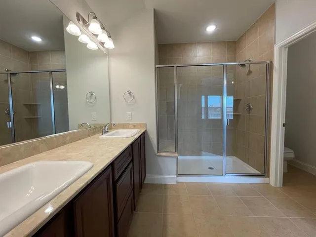 a bathroom with a shower sink and mirror