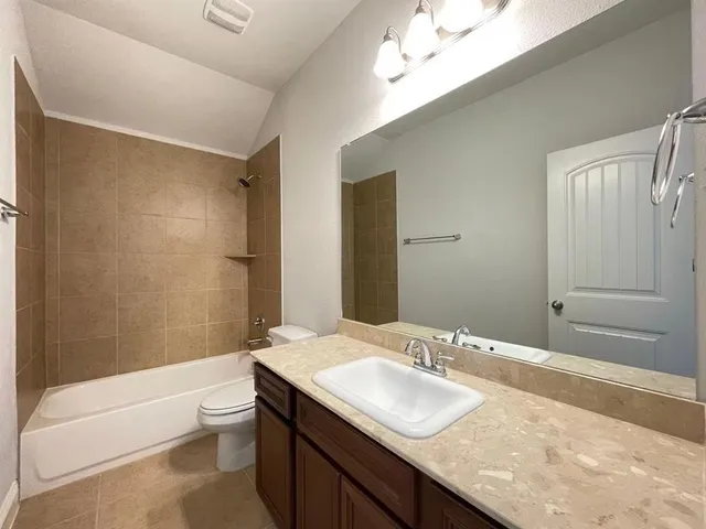 a bathroom with a granite countertop sink a toilet and bathtub